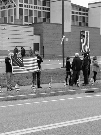An hour before the procession the community came out with flags and signs for Corporal John. M. Dawson